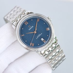 Alternative view of BLS Omega De Ville Collection     Original Mold Master Chronometer This timepiece is crafted from stainless steel, featuring a domed dial treated with deep blue PVD coating. Its surface bears irregular vertical grooves, creating a sunray-brushed finish. Particularly striking are the rhodium-plated hands, Roman numeral hour markers, and alternating cabochon-set hour indices.A date window is positioned at the 6 o'clock mark, while the dial is adorned with a "railway" minute track, complementing the watch's minimalist aesthetic. It is fitted with a stainless steel bracelet. Clasp type: butterfly clasp. Powered by the Omega 8800 Master Chronometer movement with a black balance wheel, the movement's elegant operation is clearly visible through the scratch-resistant sapphire crystal caseback.